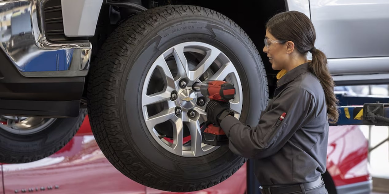A Mechanic Is Drilling Screws to Attach a Wheel to a Vehicle