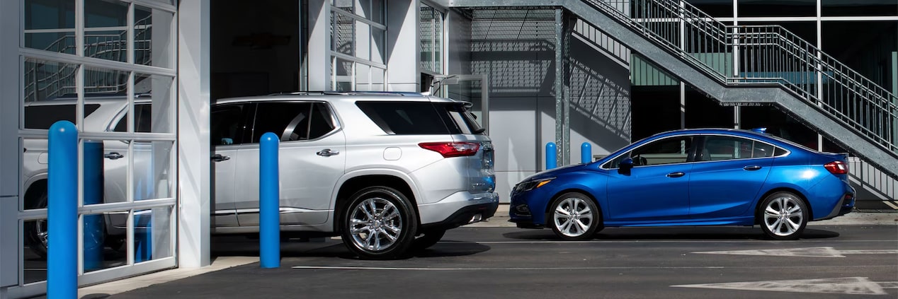 Side View of a Silver Vehicle with a Blue Vehicle Behind It