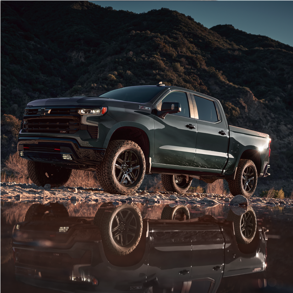Silverado 1500 Trail Boss Driving on Mountainous Terrain Near a Reflective Puddle