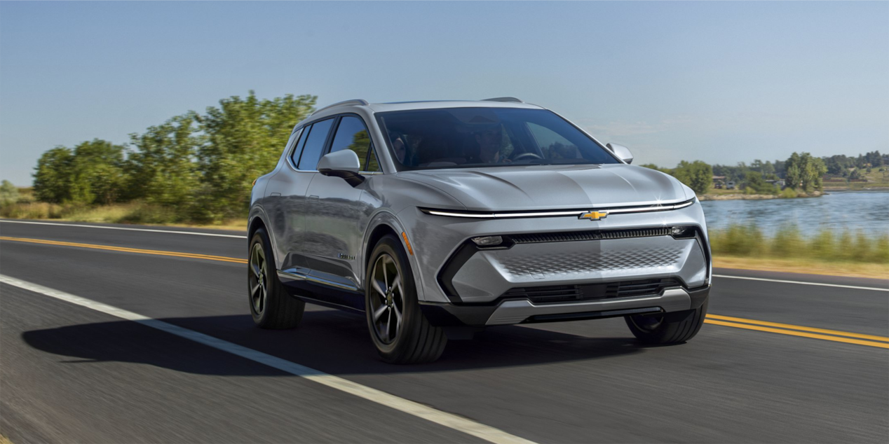 Chevrolet Equinox EV circulando por un camino al costado de un lago