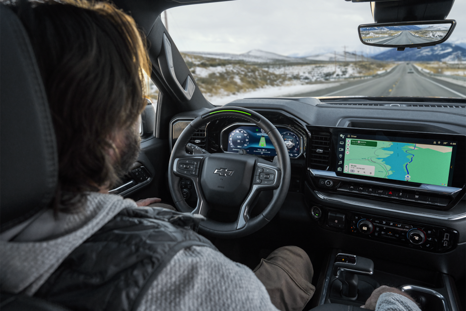 Un hombre utilizando la tecnología de conducción manos libres Super Cruise en su vehículo Chevy