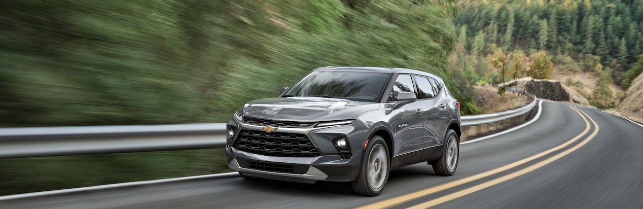 A Chevy SUV Drives Down a Winding Mountain Road