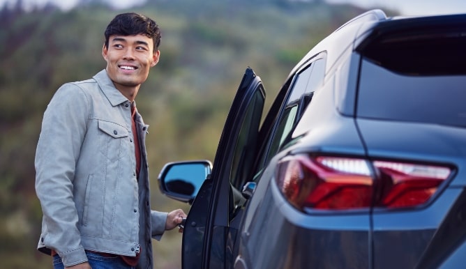 El propietario de un vehículo Chevy estacionado con la puerta abierta