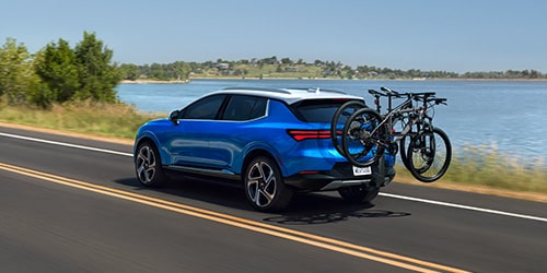 Rear View of a Chevy SUV Driving with a Bike Mounted on the Back