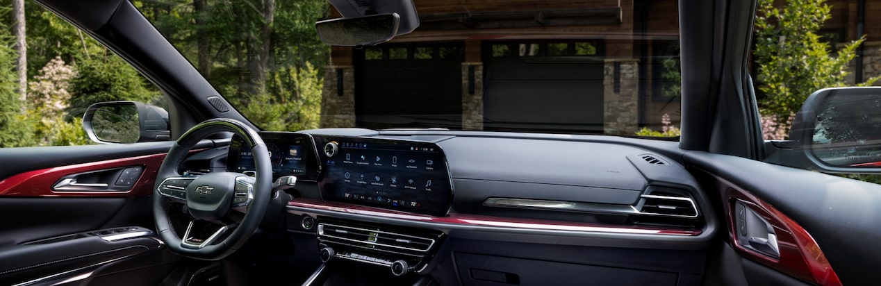 Interior de un vehículo Chevrolet estacionado frente a un garaje para dos autos