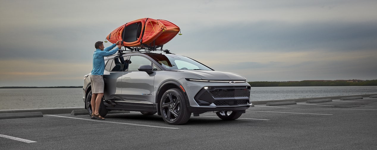 Person loading Kayaks on roof of Vehicle