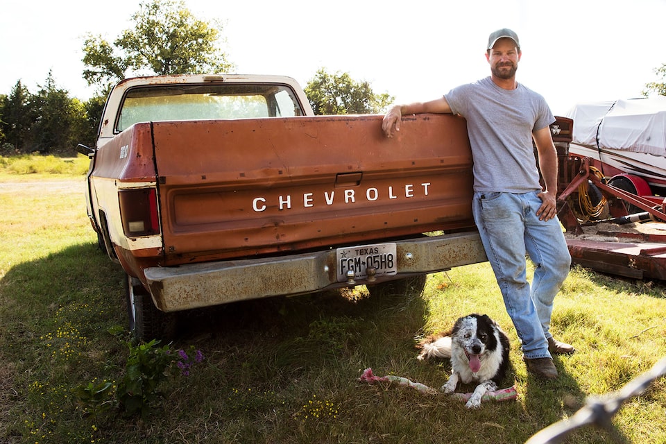 A Man and His Dog Leaning on the Bed of His 1970s Chevy Truck