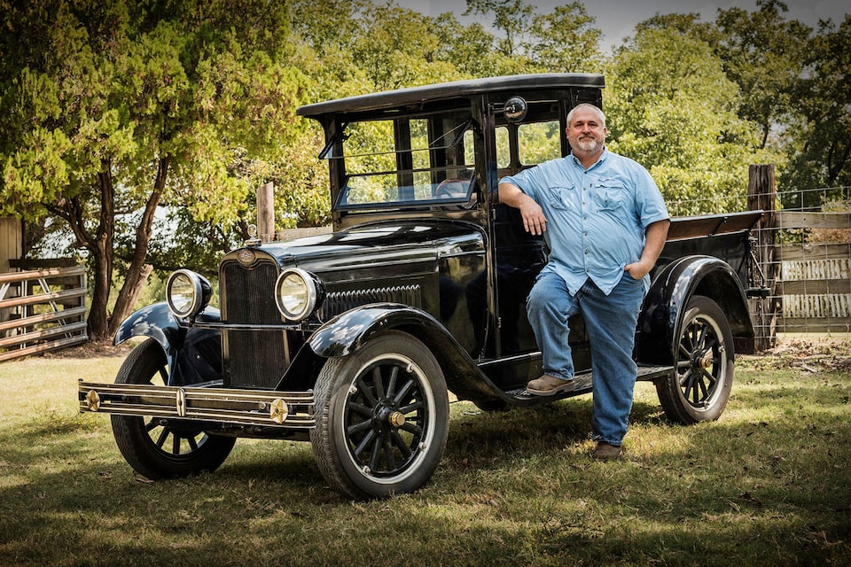 A Man Posing with His 1918 Chevy Model T in a Park