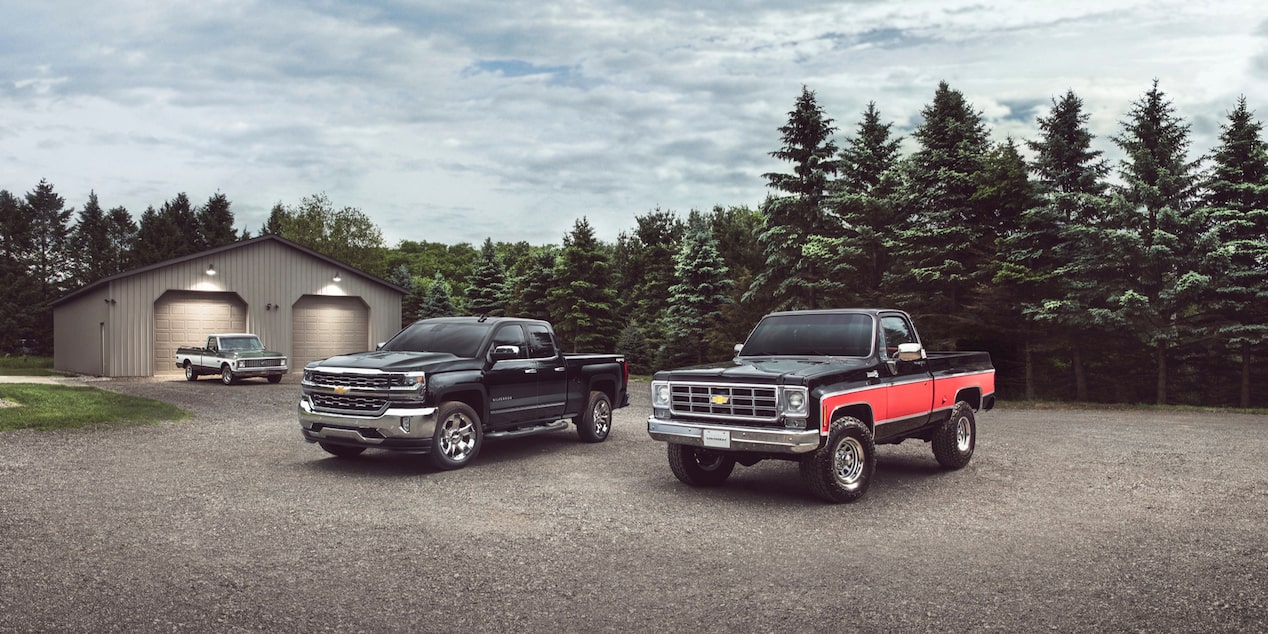 Multiple Generations of Chevy Trucks Parked Outside a Garage 