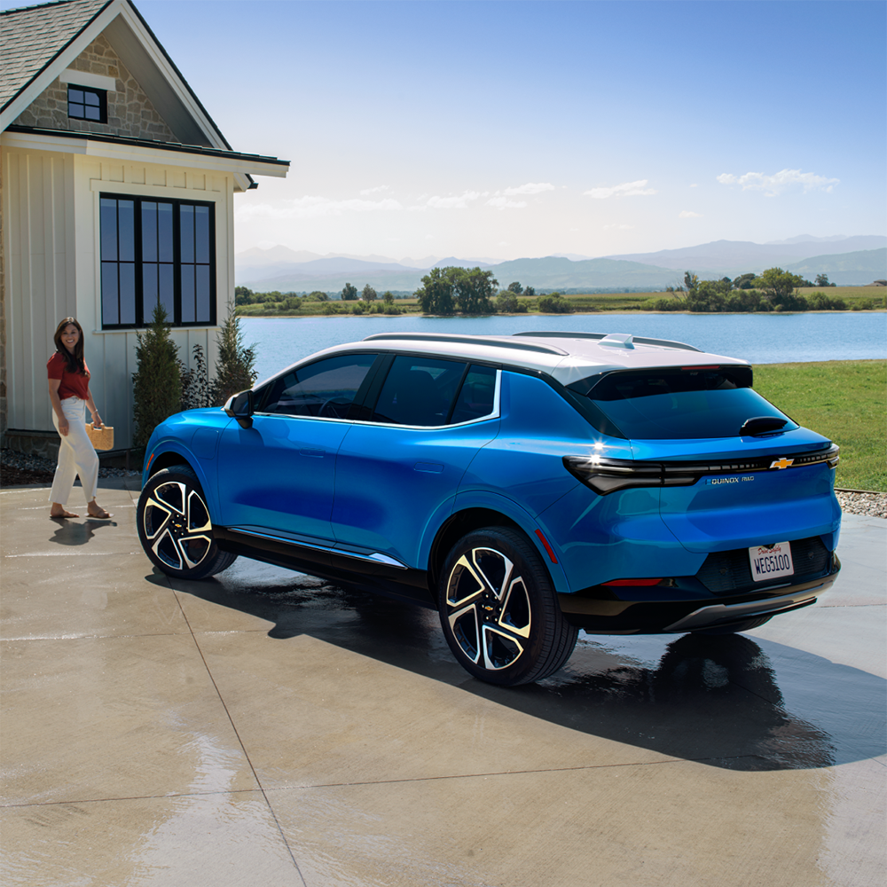 Rear View Driver's Side of Blue 2024 Chevrolet Equinox EV Parked in Driveway in the Sun