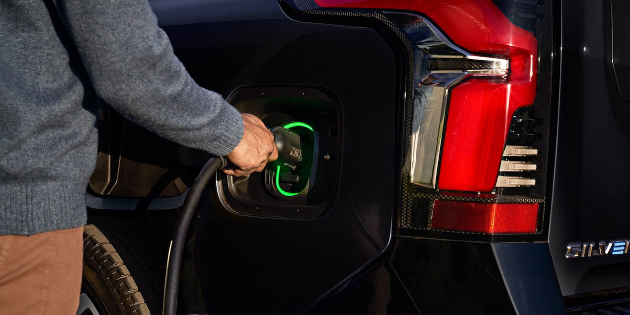 A Person Plugging in their Silverado EV with a Charger