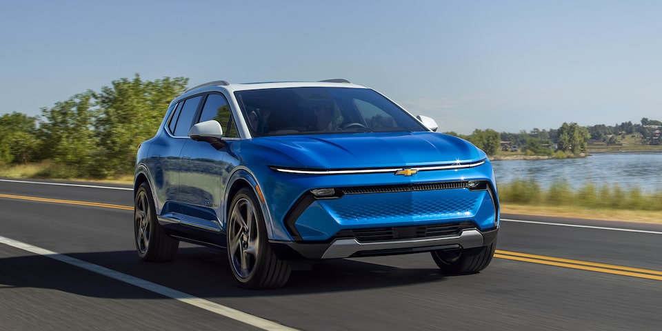 Three-Quarters View of a 2025 Blue Chevrolet Equinox Driving Down the Road