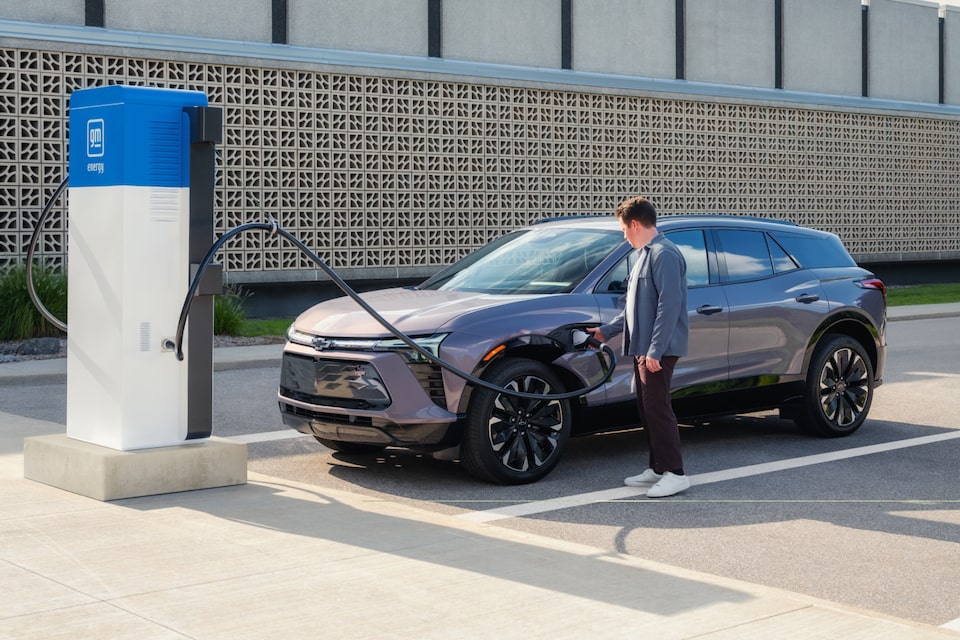 Hombre cargando un Chevrolet EV 2025 en una estación de carga al aire libre