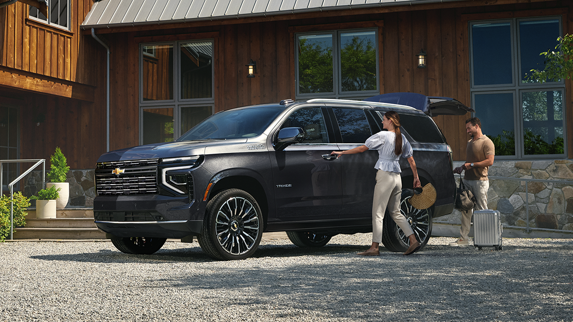 A Couple Loading Up Luggage Into the Trunk of Their 2025 Chevy Tahoe