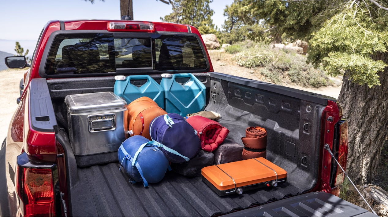 Rear View of the Trunk of a 2025 Red Chevy Colorado with Camping Gears, and Other Traveling Equipment