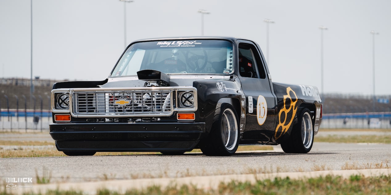 Vista frontal lateral de una camioneta Chevy R10 de 1987 con calcomanías de Racing Autocross