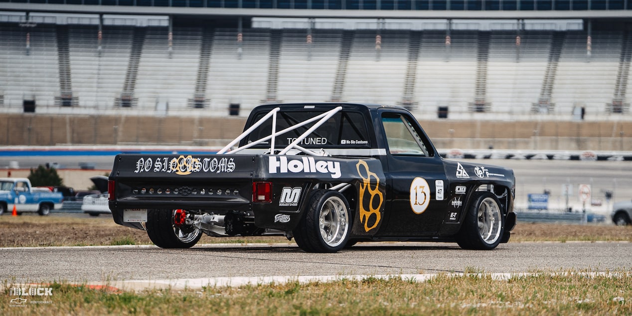 Vista trasera de tres cuartos de una camioneta Chevy R10 de 1987 con calcomanías de Racing Autocross